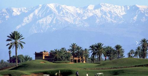 a house on a golf course with mountains in the background at Villa Jude Luxury 6BR Villa with Private Pool, Sleeps 12, Near Golf & City in Marrakesh
