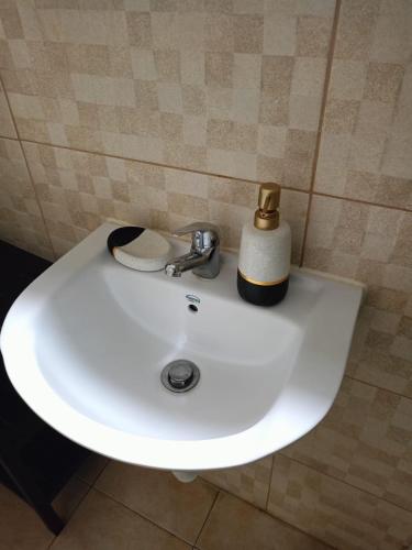 een witte wastafel met een fles zeep erop bij Alexandroupolis City Home Eftelya 50m City Best Location in Alexandroupoli