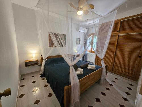 a bedroom with a bed with a canopy at private Villa mit eigenem Pool unter Palmen in Cala Llenya