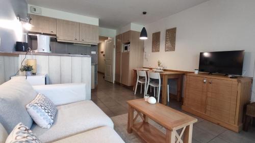 un soggiorno con divano e cucina di Argousiers 20 a Fort-Mahon-Plage