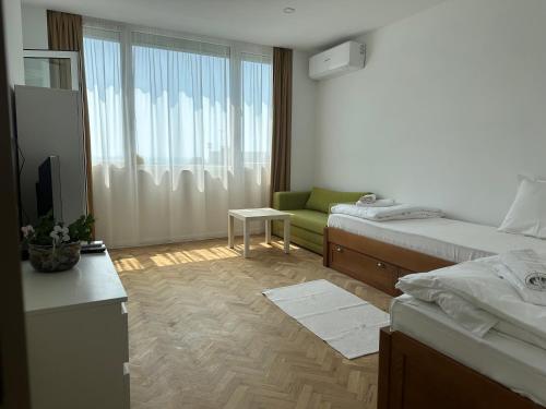 una camera da letto con due letti, un divano e una finestra di Guest Rooms Boutique Varna a Varna