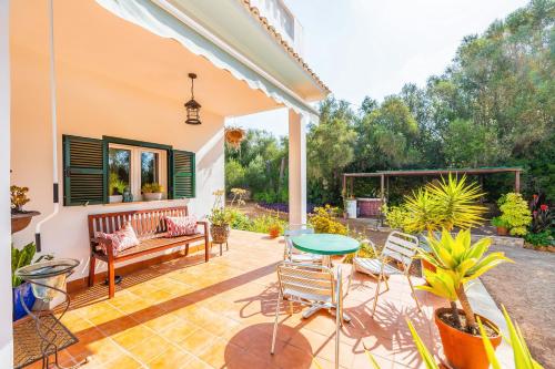 a patio with a bench and a table and chairs at Sa Rota de can Xito in Sencelles
