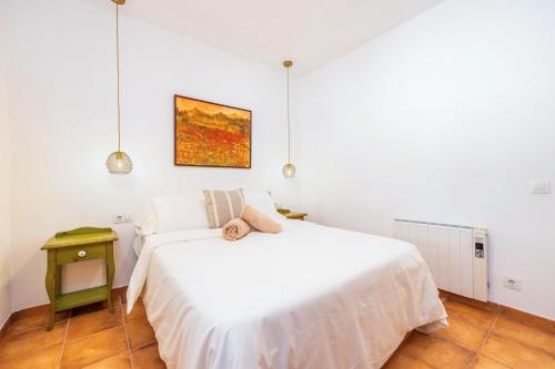 a bedroom with a white bed with a teddy bear on it at Sa Rota de can Xito in Sencelles
