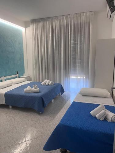 two beds in a bedroom with blue and white at B&B a casa di Sonia in Termoli