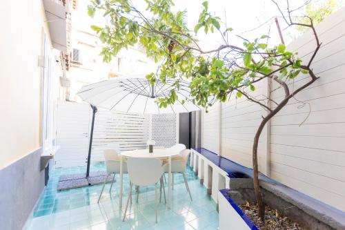 a small balcony with a table and chairs and a tree at Assoli House in Naples
