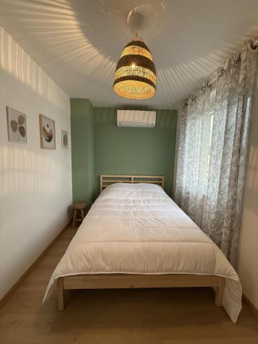 une chambre avec un lit et un lustre dans l'établissement Le Moderne, à Montchanin