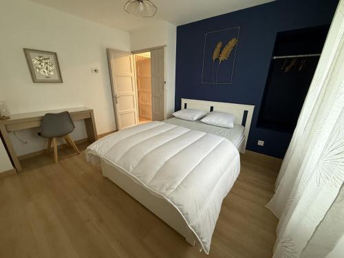 une chambre avec un lit blanc et une chaise dans l'établissement Le Moderne, à Montchanin