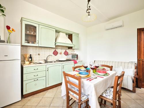 a kitchen with a table with chairs and a white refrigerator at Casa Vacanze Santa Caterina in Asciano