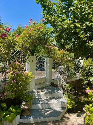 a garden with a gate and stairs with flowers at Apartment Milinkovic in Niška Banja