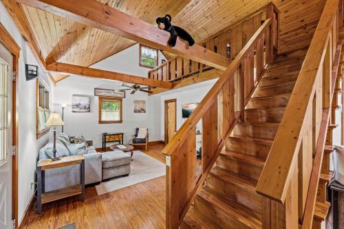 a staircase in a living room with wooden ceilings at Bear Tracks Lodge By Avada Properties in Sevierville