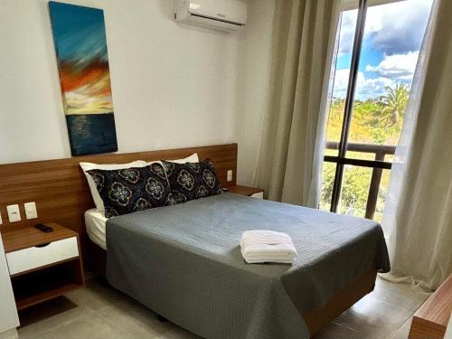 a bedroom with a bed and a large window at Condomínio Wai Wai Pé na Areia - Praia de Cumbuco in Cumbuco