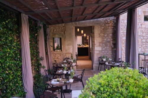 a patio with tables and chairs and a building at Can Aulí Luxury Retreat - Adults Only in Pollença