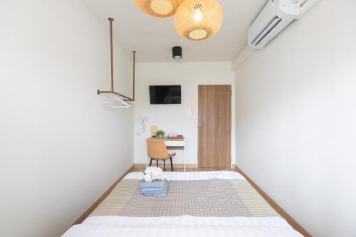 ein kleines Zimmer mit einem Bett und einem Stuhl in der Unterkunft Ease at Sathorn Hostel and Coworking Space in Bangkok