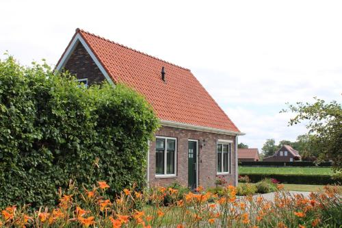 a small brick house with an orange roof at Sint Anthonijshoek in Koudekerke