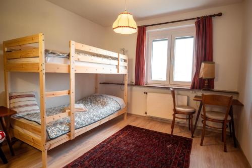 a bedroom with two bunk beds and a table at Ferienwohnung im Haus am Hügel in Sankt Georgen am Längsee