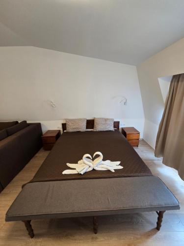 a bed with two white flowers on top of it at Hotel Sax Balkan in Dimitrovgrad