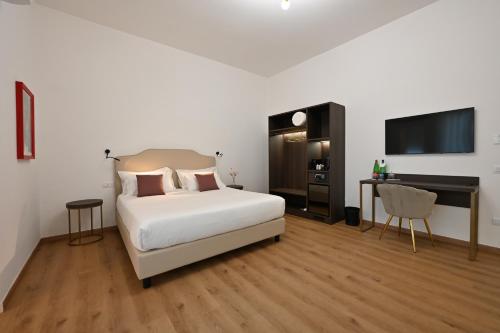 a bedroom with a bed and a desk and a television at Spazio83 Comfort Rooms in Fisciano