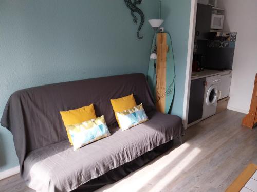 - un canapé avec trois oreillers dans l'établissement Biscarrosse-plage jolie maisonnette avec terrasse privative - 200m de la plage, à Biscarrosse
