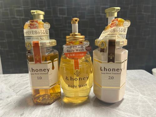 three bottles of honey sitting on a table at メルシアターリゾート1001 in Wada