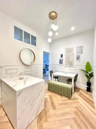 - une cuisine blanche avec une table et un miroir dans l'établissement Appartement Haussmannien Gare Centre-ville Clim, à Montpellier