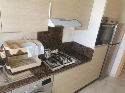 a kitchen with a sink and a counter top at Casabay Appart Vue Sur Piscine in Sidi Rahal
