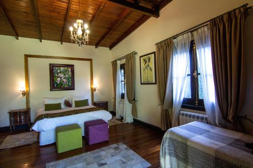 a bedroom with two beds and a chandelier at Puesto Viejo in Cañuelas