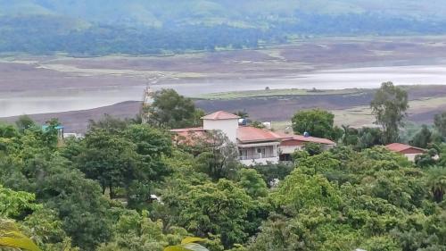a house on top of a hill with trees at Machan Villas by Holiday Club in Bhor