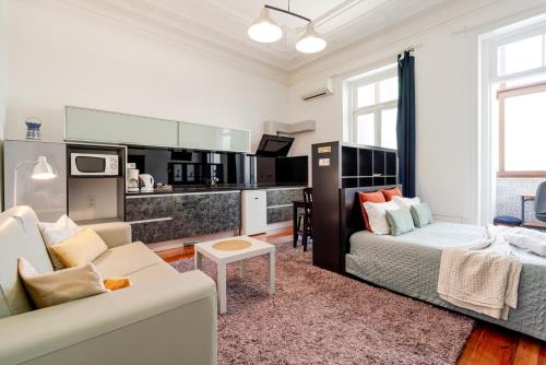 a living room with a couch and a kitchen at Gardenia Urban Retreat in Porto