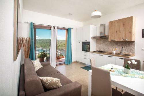 a kitchen and living room with a couch and a table at Casa Miramar e Casa Solemar in Santa Teresa Gallura