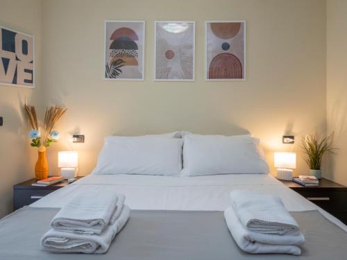 a bedroom with a white bed with towels on it at Spazio Breda - Free Parking, Private Garage, Metro M1, Balcony, 4 Guests in Milan