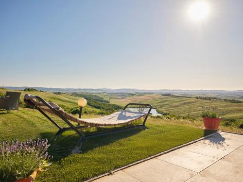 a hammock sitting on top of a grassy hill at Casa Vacanze Santa Caterina in Asciano