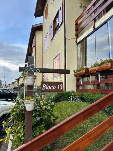 a street sign on a pole in front of a building at ESPAÇO INTEIRO Fleur in Campos do Jordão