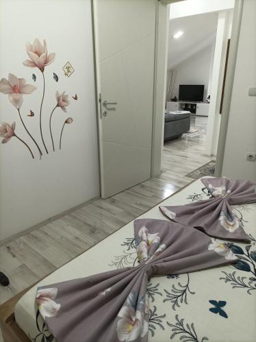 a bedroom with a bed with flowers on the wall at Ceca Apartment in Gevgelija