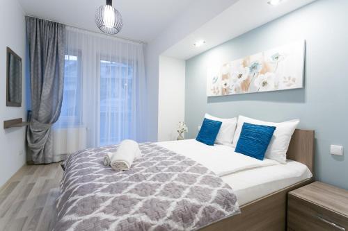a bedroom with a large bed with blue pillows at VIP Apartamenty Stara Polana in Zakopane