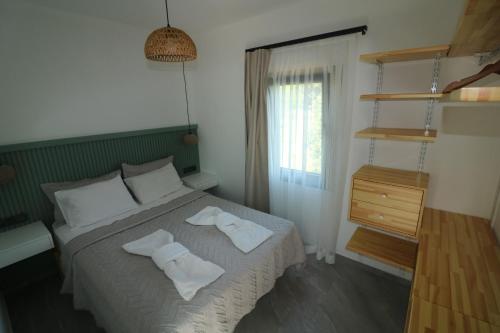 a bedroom with a bed with two towels on it at Paradise Garden Apartments in Gumusluk