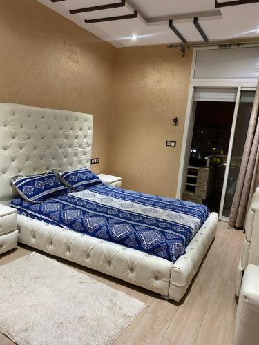 een slaapkamer met een bed met een blauw dekbed bij Av des far agadir in Agadir