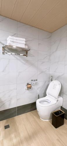 a bathroom with a white toilet and a glass wall at 隱 Villa 旅宿 in Chaozhou