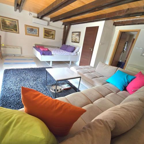 a living room with a couch with colorful pillows at Villa tennis Sarajevo in Ledići