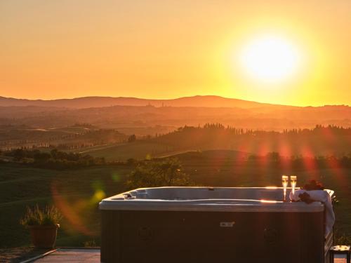a bath tub with the sunset in the background at Casa Vacanze Santa Caterina in Asciano