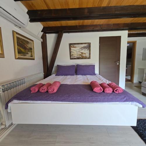 a large bed with pink pillows in a bedroom at Villa tennis Sarajevo in Ledići