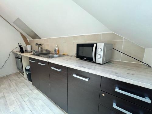 a kitchen with a microwave on top of a counter at Appartement au centre in Charleville-Mézières