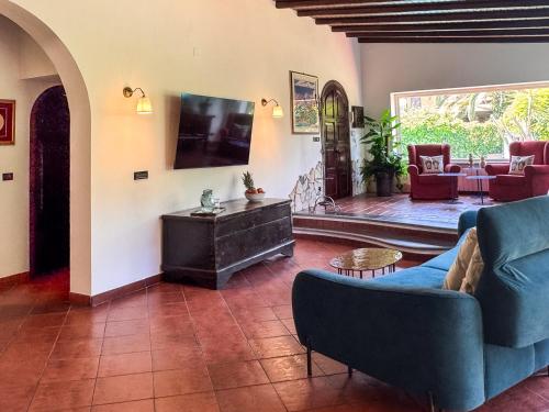 a living room with a blue couch and a tv at Villa Etna in San Giovanni la Punta