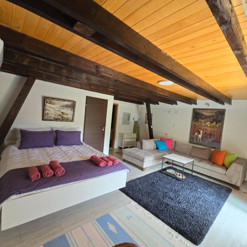 a bedroom with a large bed and a couch at Villa tennis Sarajevo in Ledići