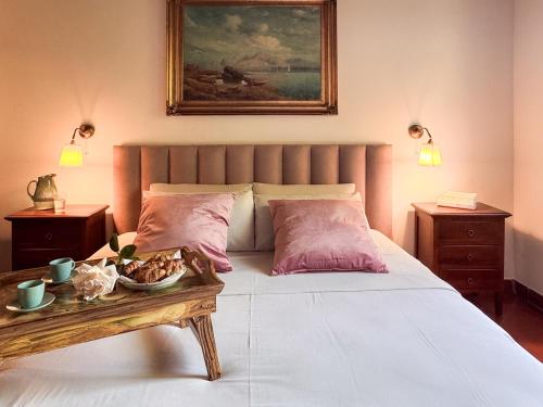 a bedroom with a bed with a table and a painting at Villa Etna in San Giovanni la Punta