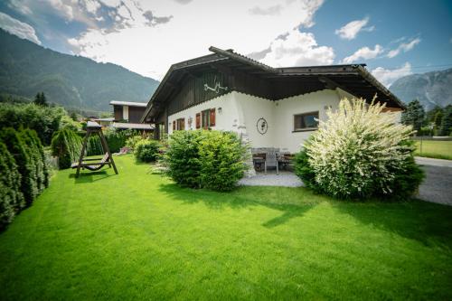 a house with a green lawn in front of it at Ferienhaus Ötztal-Lodge in Sautens