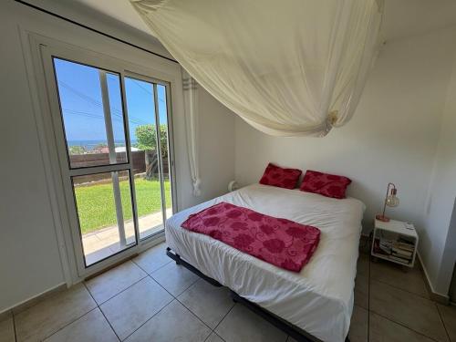 a bedroom with a bed and a large window at Villa Morne-Bou in Petit-Bourg