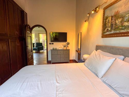 a bedroom with a large white bed and a dresser at Villa Etna in San Giovanni la Punta
