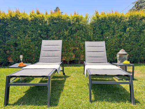 two chairs and a table in the grass at Villa Etna in San Giovanni la Punta