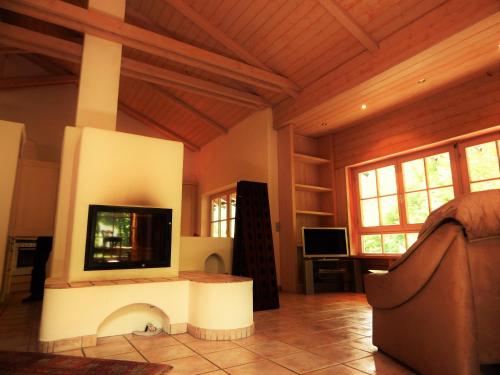 a living room with a flat screen tv on a fireplace at Hotel Königsseer Hof in Schönau am Königssee