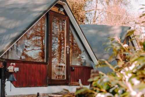 a window of a house with a dog in it at Chambre avec jacuzzi ou Chalets dans les bois in Gesves